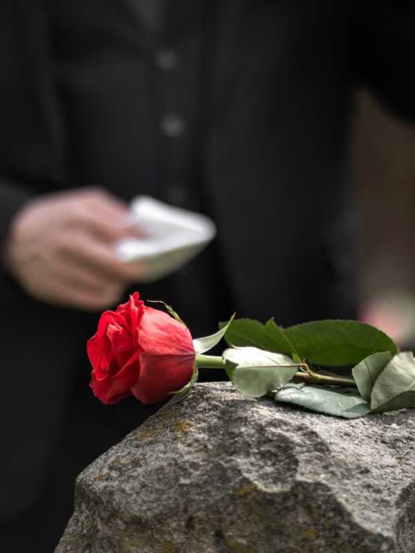 man-paying-respect-tombstone-cemetery